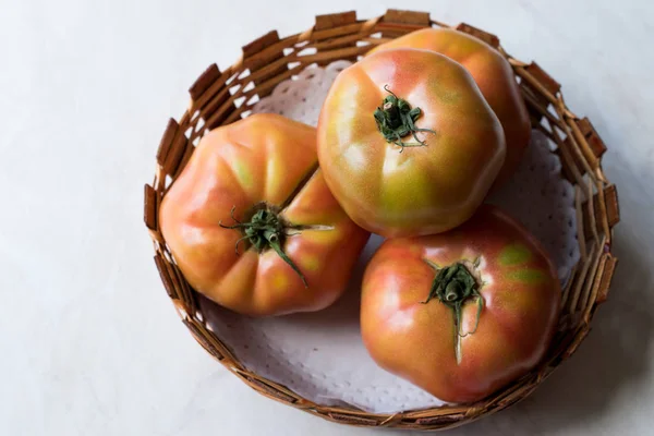 Pink Organic Big Tomatoes in Wooden Basket. Organic Food.