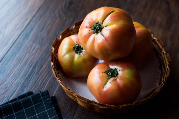 Pink Organic Big Tomatoes in Wooden Basket. Organic Food.