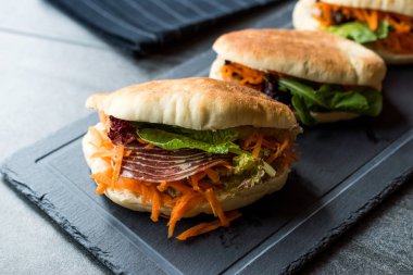 Tayvan'ın pide ekmek Bun sandviç Gua Bao Füme pastırma, havuç dilimleri ve Yeşiller Asya'dan. Pastırma / pastırma sandviç