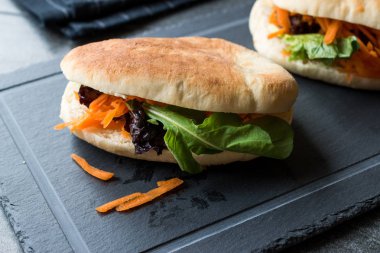 Vegan / Vejetaryen pide ekmek Bun sandviç Tayvan'ın Gua Bao havuç dilimleri ve yeşillik Asya ile. Geleneksel organik gıda.
