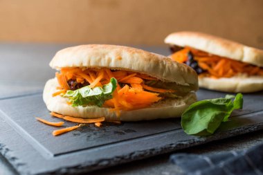 Vegan / Vejetaryen pide ekmek Bun sandviç Tayvan'ın Gua Bao havuç dilimleri ve yeşillik Asya ile. Geleneksel organik gıda.