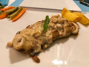 Dolması kalamar eden veya Suace, patates dilimleri ve taze sebze dilimleri ile kalamar. Organik geleneksel gıda.