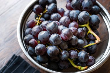 Metal kevgir içinde kırmızı üzüm demet. Organik gıda.