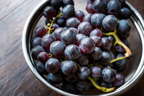 Metal kevgir içinde kırmızı üzüm demet. Organik gıda.