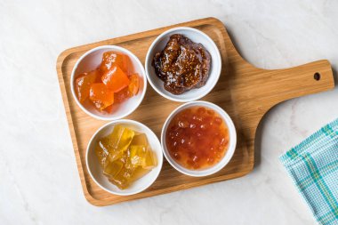 Çeşitli seramik kase meyve reçel incir, ayva, Bergamot narenciye, karpuz içinde ahşap tepsi / marmelat. Organik gıda.