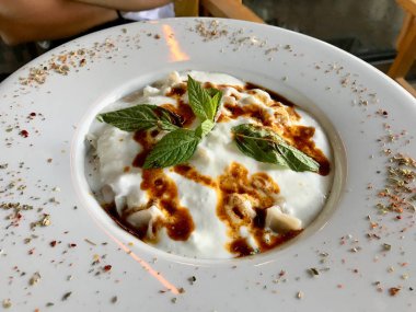Yoğurt, kızarmış tereyağı sosu ve nane yaprakları ile Türk Mantı Manlama. Geleneksel gıda.