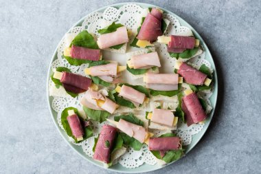 Kanepe jambon peynir ve yeşillik yuvarlak plaka ile sarılmış. Organik meze.