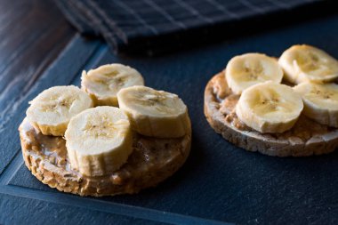 Bulgur pirinç kek dilimlenmiş muz ve fıstık ezmesi ile / kraker yuvarlak. Organik sağlıklı atıştırmalıklar.