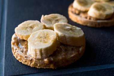 Bulgur pirinç kek dilimlenmiş muz ve fıstık ezmesi ile / kraker yuvarlak. Organik sağlıklı atıştırmalıklar.