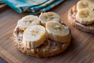 Bulgur pirinç kek dilimlenmiş muz ve fıstık ezmesi ile / kraker yuvarlak. Organik sağlıklı atıştırmalıklar.