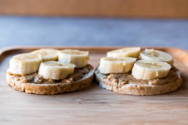 Bulgur pirinç kek dilimlenmiş muz ve fıstık ezmesi ile / kraker yuvarlak. Organik sağlıklı atıştırmalıklar.