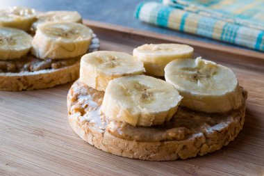 Bulgur pirinç kek dilimlenmiş muz ve fıstık ezmesi ile / kraker yuvarlak. Organik sağlıklı atıştırmalıklar.