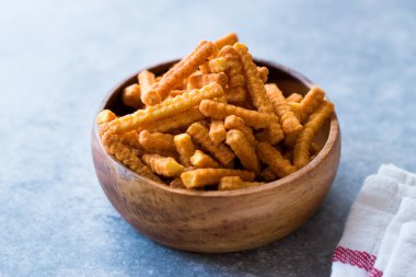 Turuncu peynir aromalı mısır aperatifler Stick Şekil / kavrulmuş cips veya ahşap kase tuzlu kraker. Organik Kavrulmuş aperatifler.