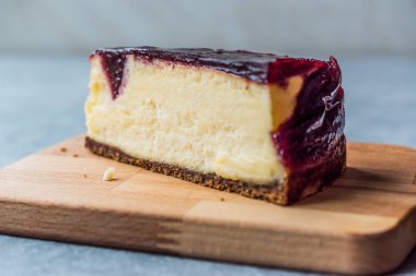 Ahududu Cheesecake dilim kağıt ile ahşap tahta üzerinde. Organik tatlı.
