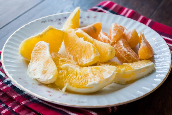 Organic Orange and Mandarin Slices in plate with Red Tablecloth. Organic Food.