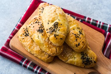Ev yapımı Türk pasta kuru fasulye kimyon tohumu ile / siyah susam ve ahşap tahta üzerinde peynir. Geleneksel ekmek yemek.