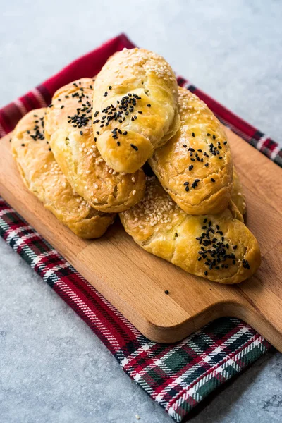 Ev yapımı Türk pasta kuru fasulye kimyon tohumu ile / siyah susam ve ahşap tahta üzerinde peynir. Geleneksel ekmek yemek.