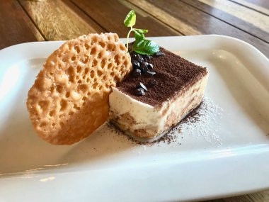 Tiramisu puding bisküvi ve kakao tozu ile restoranda servis / bisküvi ile Türk salatası. Organik tatlı.