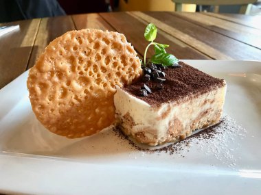 Tiramisu puding bisküvi ve kakao tozu ile restoranda servis / bisküvi ile Türk salatası. Organik tatlı.