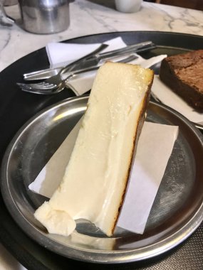 San Sebastian Cheesecake gümüş tabak / krem düz stil. Organik tatlı.