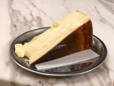 San Sebastian Cheesecake gümüş tabak / krem düz stil. Organik tatlı.