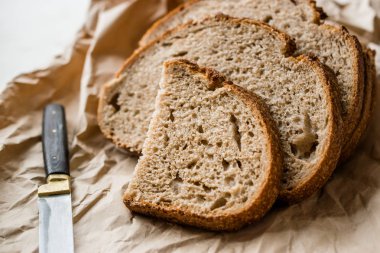 Esnaf ev yapımı hamur mayası ekmek dilimleri kese kağıdı ile dilimlenmiş / paket veya zanaat kağıt. Organik ekmek yemek.