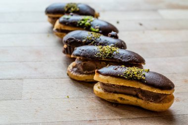 Fransız tatlı çikolata eklerleri krema ile doldurulmuş ve fıstık tozu / profiterol. Geleneksel tatlı.