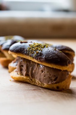 Fransız tatlı çikolata eklerleri krema ile doldurulmuş ve fıstık tozu / profiterol. Geleneksel tatlı.