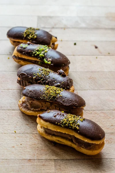 Fransız tatlı çikolata eklerleri krema ile doldurulmuş ve fıstık tozu / profiterol. Geleneksel tatlı.