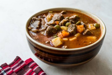 Lezzetli Macar sıcak gulaş çorbası Bograch veya restoranda ahşap yüzeyde bütün tahıl ekmeği ile Gulas kuzu eti güveç. Geleneksel yemekleri. Organik et.