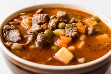 Lezzetli Macar sıcak gulaş çorbası Bograch veya restoranda ahşap yüzeyde bütün tahıl ekmeği ile Gulas kuzu eti güveç. Geleneksel yemekleri. Organik et.