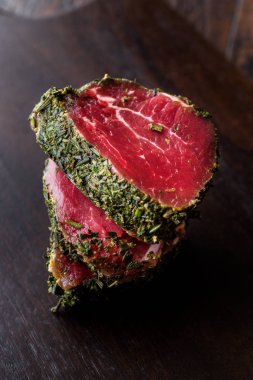 Otlar ve baharatlar ahşap tahta üzerinde ham fileto et parçaları. Organik gıda.