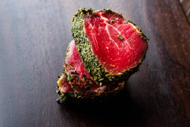 Otlar ve baharatlar ahşap tahta üzerinde ham fileto et parçaları. Organik gıda.