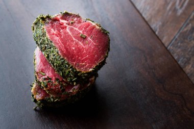 Otlar ve baharatlar ahşap tahta üzerinde ham fileto et parçaları. Organik gıda.