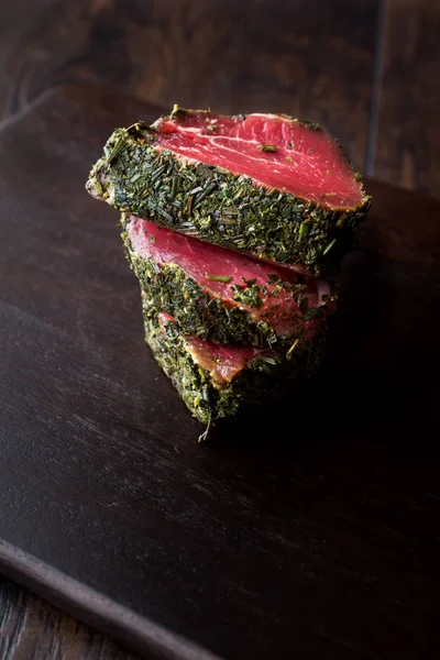 Otlar ve baharatlar ahşap tahta üzerinde ham fileto et parçaları. Organik gıda.