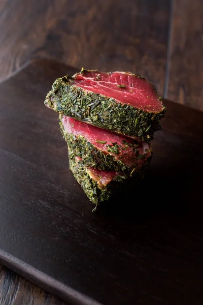 Otlar ve baharatlar ahşap tahta üzerinde ham fileto et parçaları. Organik gıda.