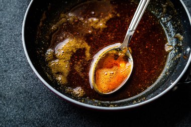Kızartma ile kırmızı sosu hazırlarken eritilmiş tereyağı ve baharat Pan / yemek tarifi kaşıkla. Ev yapımı tarifi