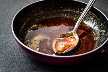 Kızartma ile kırmızı sosu hazırlarken eritilmiş tereyağı ve baharat Pan / yemek tarifi kaşıkla. Ev yapımı tarifi