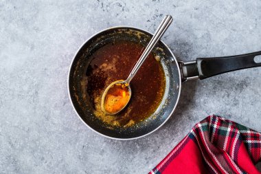 Kızartma ile kırmızı sosu hazırlarken eritilmiş tereyağı ve baharat Pan / yemek tarifi kaşıkla. Ev yapımı tarifi