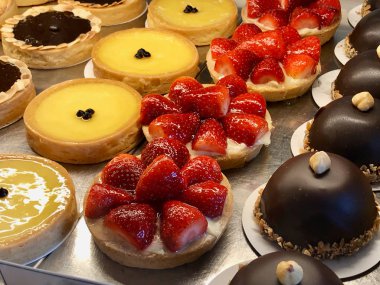 Tart, pasta, krem brulee, çilek, çikolata, limon, armut ve elma dilimleri vitrinde görüntülenen ile çeşitli pastane. Organik gıda.