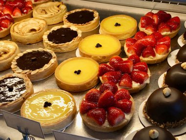 Tart, pasta, krem brulee, çilek, çikolata, limon, armut ve elma dilimleri vitrinde görüntülenen ile çeşitli pastane. Organik gıda.