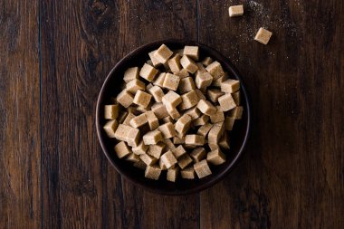 Ham organik kahverengi şeker küpleri içinde ahşap kase yemeye hazır. Gıda ürünleri.