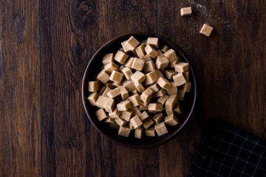 Ham organik kahverengi şeker küpleri içinde ahşap kase yemeye hazır. Gıda ürünleri.