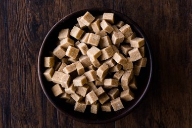 Ham organik kahverengi şeker küpleri içinde ahşap kase yemeye hazır. Gıda ürünleri.