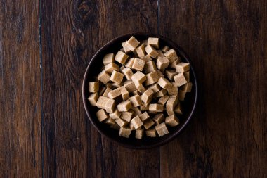 Ham organik kahverengi şeker küpleri içinde ahşap kase yemeye hazır. Gıda ürünleri.