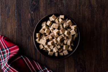 Ham organik kahverengi şeker küpleri içinde ahşap kase yemeye hazır. Gıda ürünleri.