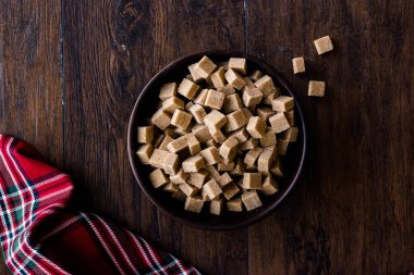 Ham organik kahverengi şeker küpleri içinde ahşap kase yemeye hazır. Gıda ürünleri.