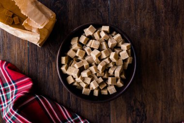 Ham organik kahverengi şeker küpleri içinde ahşap kase yemeye hazır. Gıda ürünleri.