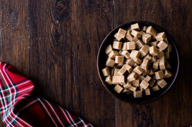 Ham organik kahverengi şeker küpleri içinde ahşap kase yemeye hazır. Gıda ürünleri.