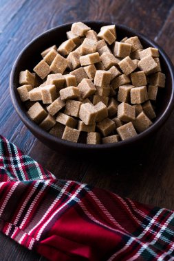 Ham organik kahverengi şeker küpleri içinde ahşap kase yemeye hazır. Gıda ürünleri.